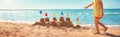 Boy building a sandcastle at the beach in summer