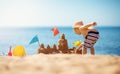 Boy building a sandcastle at the beach in summer Royalty Free Stock Photo