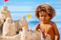 Boy building sandcastle on the beach in summer Royalty Free Stock Photo