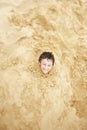 Boy Buried Upto His Neck In Sand Royalty Free Stock Photo