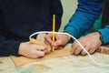 Boy burn out numbers with soldering iron on wooden disc. Kid makes wooden clock in the workshop Royalty Free Stock Photo