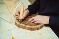 Boy burn out numbers with soldering iron on wooden disc. Kid makes wooden clock in the workshop Royalty Free Stock Photo