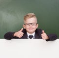 Boy in a business suit looks out from behind a banner and showing thumbs up Royalty Free Stock Photo