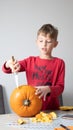 Boy busy carving a pumpkin jack-o-lantern for Halloween - removing the seeds Royalty Free Stock Photo