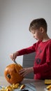 Boy busy carving a pumpkin jack-o-lantern for Halloween - removing the seeds Royalty Free Stock Photo