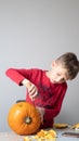 Boy busy carving a pumpkin jack-o-lantern for Halloween - removing the seeds Royalty Free Stock Photo