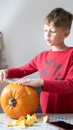 Boy busy carving a pumpkin jack-o-lantern for Halloween - removing the seeds Royalty Free Stock Photo