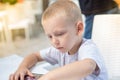 Boy in a cafe, sitting and looking menu