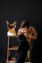 a boy with a cake, he has a birthday, a boy wearing a beige t-shirt and green pants on a black background Royalty Free Stock Photo