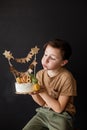 a boy with a cake, he has a birthday, a boy wearing a beige t-shirt and green pants Royalty Free Stock Photo