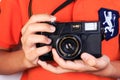 Boy with camera on orange shirt background.