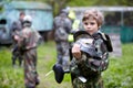 Boy in camouflage holds a paintball gun barrel up Royalty Free Stock Photo