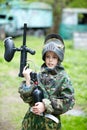 Boy in camouflage suit holds a paintball gun