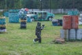 Boy in camouflage suit stands on the paintball field with his paintball gun up and looks straight ahead. team work, sport Royalty Free Stock Photo