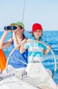 Boy captain with his sister on board of sailing yacht on summer cruise. Travel adventure, yachting with child on family Royalty Free Stock Photo
