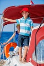 Boy captain with his sister on board of sailing yacht on summer cruise. Travel adventure, yachting with child on family Royalty Free Stock Photo