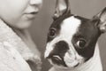 The boy cares, loves and tenderly embraces his devoted friend the Boston Terrier dog. Black and white photo. Royalty Free Stock Photo