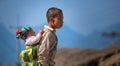 Boy carries baby in traditional hill tribe hat on his back.