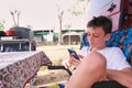 Boy using smartphone outside caravan