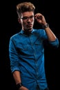 Boy in casual denim shirt posing in dark studio Royalty Free Stock Photo