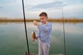 A boy catches a fish on fishing rod. men's hobby. Royalty Free Stock Photo