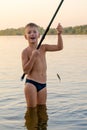 Boy catches fish in the river. Royalty Free Stock Photo