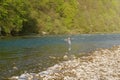 Boy catching fish in a mountain river. Throws the fishing rod Royalty Free Stock Photo