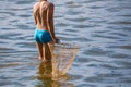 A boy is catching a fish net in the pond Royalty Free Stock Photo