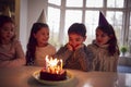 Boy Celebrating Birthday With Group Of Friends At Home Being Given Cake Decorated With Sparkler Royalty Free Stock Photo