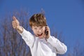 Boy with cell phone posing thumbs up Royalty Free Stock Photo