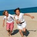 Boy chasing girl on beach.