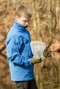 Boy checking his catch in fishing net Royalty Free Stock Photo