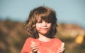 Boy child eating watermelon with funny face, green nature background. Close-up photo of kids eating sweet red melon. Royalty Free Stock Photo