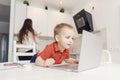 Boy child enthusiastically watching video blog or cartoons on laptop screen. Concept myopia, internet addiction