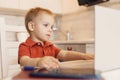 Boy child enthusiastically watching video blog or cartoons on laptop screen. Concept myopia, internet addiction Royalty Free Stock Photo