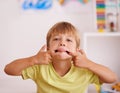 Boy, child and funny face with tongue out, goofy and playful in playroom, mischievous or naughty with humor. Comic Royalty Free Stock Photo