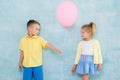 Boy child gives a balloon to a girl. Signs of attention, sympathy and courtship.