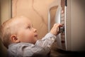 Boy child kid playing with timer of microwave oven Royalty Free Stock Photo