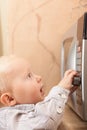 Boy child kid playing with timer of microwave oven Royalty Free Stock Photo