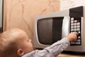 Boy child kid playing with timer of microwave oven Royalty Free Stock Photo