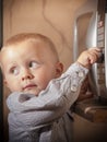 Boy child kid playing with timer of microwave oven Royalty Free Stock Photo