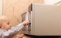 Boy child kid playing with timer of microwave oven Royalty Free Stock Photo