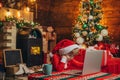 Boy child with laptop near christmas tree. Buy christmas gifts online. Christmas shopping concept. Gifts service. Santa Royalty Free Stock Photo