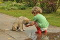 Boy, child in red rubber Wellingtons talking with the puppy. Childhood in diapers.