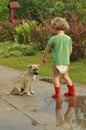 Boy, child in red rubber Wellingtons, talking with the puppy. Childhood in diapers