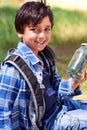 Boy, child and smile with jar in nature, exploring and learning on adventure, hiking in park or woods for fun. Portrait Royalty Free Stock Photo