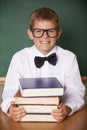 Boy child, smile and portrait with books, classroom and learning for exam, assessment and studying for knowledge Royalty Free Stock Photo