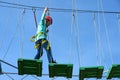 Boy child steps on wooden boards on the obstacle course in an amusement park, outdoor activities, rock climbing, danger, training, Royalty Free Stock Photo