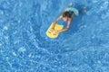 Boy child swim in swimming pool using board. Active summer vacation in resort hotel. Vacation, holiday, water sports Royalty Free Stock Photo