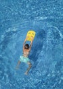 Boy child swim in swimming pool using board. Summer vacation in resort hotel. Water sports Royalty Free Stock Photo